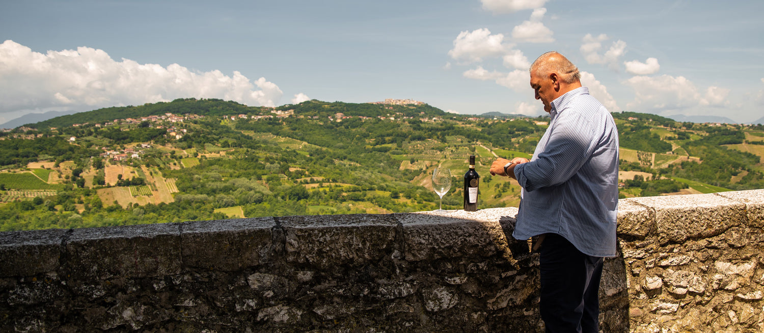 Luigi Caggiano apre una bottiglia di Taurasi DOCG sul terrazzo che affaccia su Taurasi